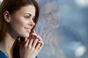 pretty woman sitting on the windowsill with a blue plaid morning photo