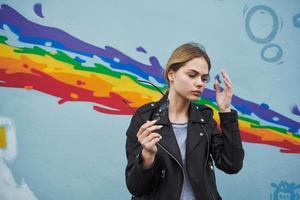 Women near the graffiti on the wall in the form of a rainbow in the street photo