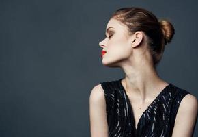 Side view of beautiful woman in black dress with hairstyle photo