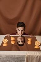 modelo hombre a mesa con naranjas y tela antecedentes foto