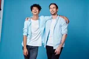 best friends hugging on blue background in matching t-shirts cropped view photo