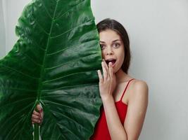 mujer en rojo traje de baño palma hoja sonrisa glamour exótico foto