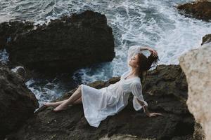 woman in a white dress lying on a stone in a white dress nature landscape photo