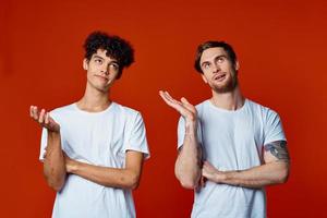 two friends in white t-shirts stand side by side isolated background communication photo
