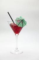 Red cocktail drink with green umbrella isolated on a white background. photo