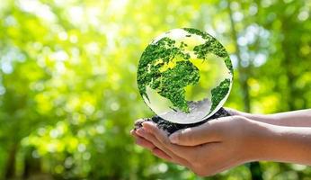 Concept Save the world save environment The world is in the grass of the green bokeh background photo