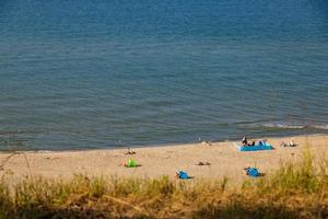 ver desde el escarpa a el playa en el báltico mar en un verano día con personas foto