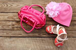 Children's shoes, hat and handbag on wooden background. Toned image. photo