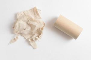 Crumpled toilet paper and empty toilet paper roll on white background photo