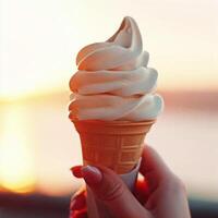 Vanilla cream ice-cream cone in woman hand on sunset. photo