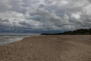 wide beach on the Baltic Sea in Poland on a summer cloudy gray cold day photo