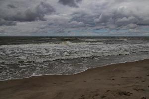 wide beach on the Baltic Sea in Poland on a summer cloudy gray cold day photo