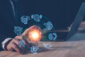 AI technology concept, man using AI tech to working business project, businessman working on computer laptop and touching light bulb with AI icons, creative and new idea concept. photo