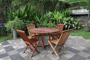 Wooden chairs and table in the garden with tropical plants photo