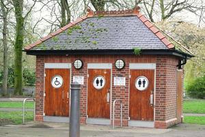 Wardown Public Park's Toilet Building which is opened by Local Currency Coins to Use Facility. The Image Was Captured at Park of Luton Town of England During a Cold and Cloudy Evening of 01-April-2023 photo