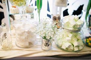barra de dulces de boda con flores blancas en estilo rústico foto