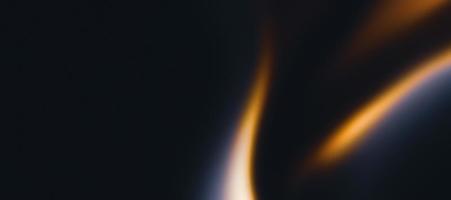Golden flame on black grainy textured background, abstract blurred orange waves on dark noise texture, copy space photo