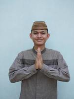 Moslem Asian man smiling to give greeting during ied celebration photo