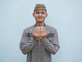 retrato de joven asiático musulmán hombre levantamiento manos en oración foto