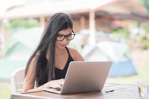 Young woman wearing smartwatch using laptop computer. Female working on laptop photo