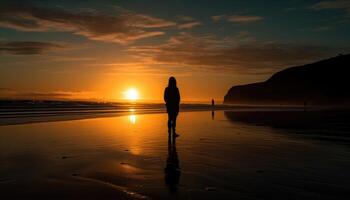 Photo of a sunset silhouette with a person standing on a beach at sunset.