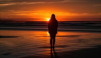 Photo of a sunset silhouette with a person standing on a beach at sunset.