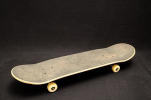 Isolated skateboard on black photo