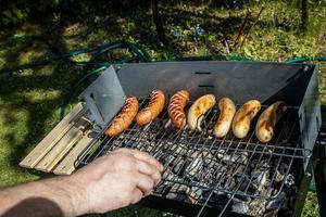 hot sausages lying on a hot grill close-up outside photo