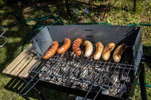 hot sausages lying on a hot grill close-up outside photo