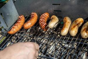 caliente salchichas acostado en un caliente parrilla de cerca fuera de foto