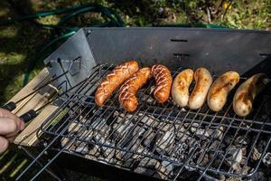 hot sausages lying on a hot grill close-up outside photo