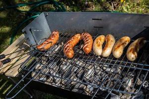 hot sausages lying on a hot grill close-up outside photo