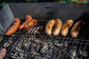 hot sausages lying on a hot grill close-up outside photo