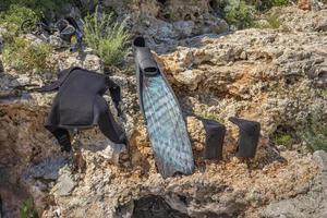 Wet parts of diving equipment drying out in the sun on the rocks photo