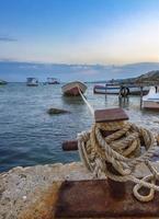 Amazing long exposure landscape at rope anchoring fishing boat at the pier. photo