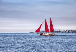 Beautiful composition and mood of a sailing sailboat with red sails photo