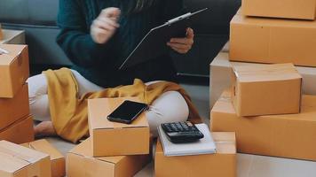 Business woman start up small business entrepreneur SME success .freelance woman working at home with Online Parcel delivery. SME and packaging deliveryconcept video