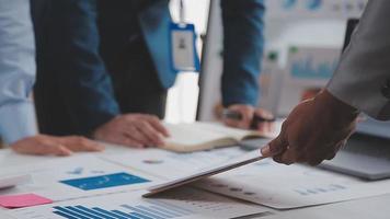 Financial analysts analyze business financial reports on a digital tablet planning investment project during a discussion at a meeting of corporate showing the results of their successful teamwork. video