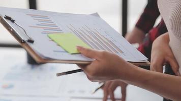 Financial analysts analyze business financial reports on a digital tablet planning investment project during a discussion at a meeting of corporate showing the results of their successful teamwork. video
