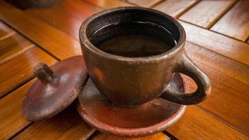 A cup Coffee with traditional cup from Jepara Central Java. The photo is suitable to use for coffee shop background and content media.