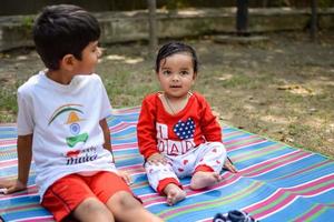 Two happy boys in society park, happy Asian brothers who are smiling happily together. Brothers play outdoors in summer, best friends. Toddler baby boy playing with his happy brother in the garden photo