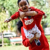 Loving mom carrying of her baby at society park. Bright portrait of happy mum holding child in her hands. Mother hugging her little 9 months old son. photo