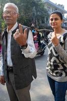 New Delhi, India - December 04 2022 - Unidentified people showing their ink-marked fingers after casting votes in front of polling booth of east Delhi area for MCD local body Elections 2022 photo