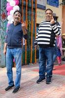 New Delhi, India - December 04 2022 - Unidentified people showing their ink-marked fingers after casting votes in front of polling booth of east Delhi area for MCD local body Elections 2022 photo