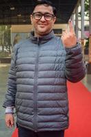 New Delhi, India - December 04 2022 - Unidentified people showing their ink-marked fingers after casting votes in front of polling booth of east Delhi area for MCD local body Elections 2022 photo