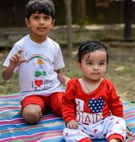 dos contento Niños en sociedad parque, contento asiático hermanos quien son sonriente felizmente juntos. hermanos jugar al aire libre en verano, mejor amigos. niñito bebé chico jugando con su contento hermano en el jardín foto