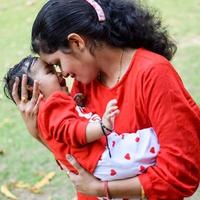 amoroso mamá que lleva de su bebé a sociedad parque. brillante retrato de contento mamá participación niño en su manos. madre abrazando su pequeño 9 9 meses antiguo hijo. foto