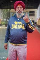 New Delhi, India - December 04 2022 - Unidentified people showing their ink-marked fingers after casting votes in front of polling booth of east Delhi area for MCD local body Elections 2022 photo