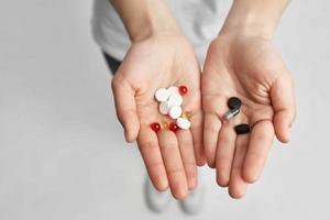sick woman pills in hand pain reliever light background photo