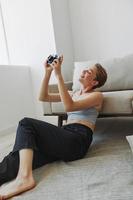 Happy smile woman holding an old camera and taking pictures of herself as a weekend photographer in home clothes with a short haircut hair without filters on a white background, free copy space photo